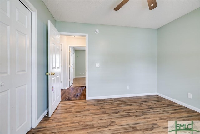 empty room featuring hardwood / wood-style floors, ceiling fan, and a textured ceiling