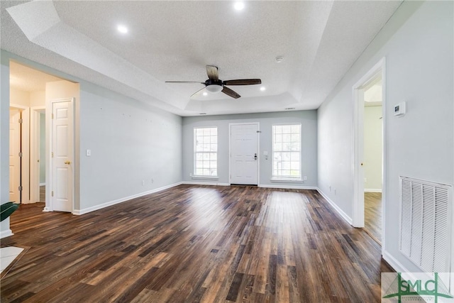 spare room featuring dark hardwood / wood-style flooring, a tray ceiling, and ceiling fan