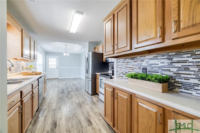 kitchen with an inviting chandelier, sink, decorative backsplash, a textured ceiling, and stainless steel appliances