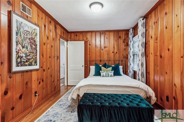 bedroom with wood-type flooring and ornamental molding