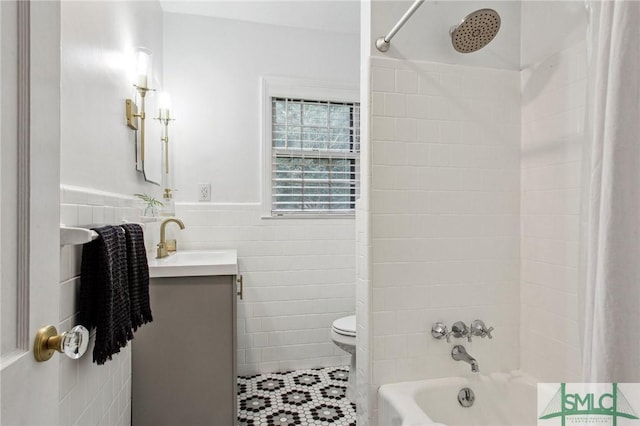 full bathroom with shower / bath combo, vanity, toilet, and tile walls