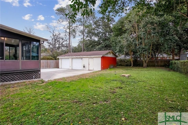 view of yard with an outbuilding, a patio, a garage, and a sunroom