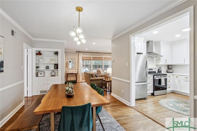 dining room featuring a chandelier, light hardwood / wood-style flooring, and ornamental molding