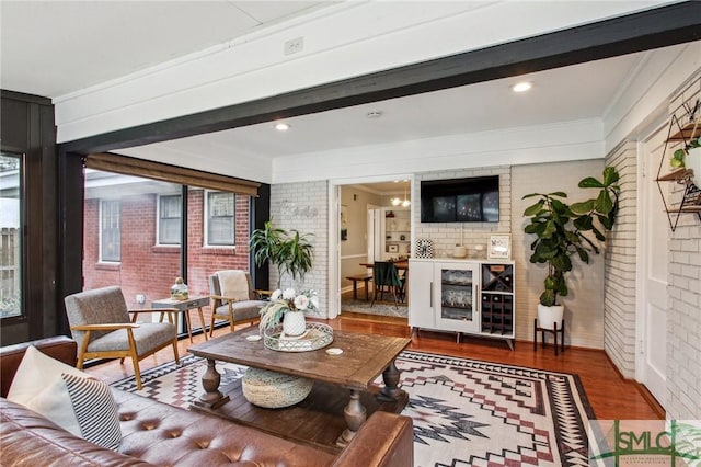 living room featuring dark hardwood / wood-style floors, plenty of natural light, and brick wall