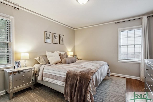 bedroom with dark hardwood / wood-style floors, multiple windows, and ornamental molding