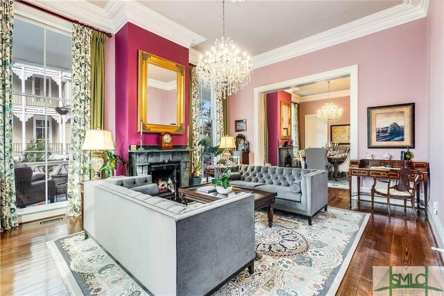 living room with a chandelier, ornamental molding, and dark wood-type flooring