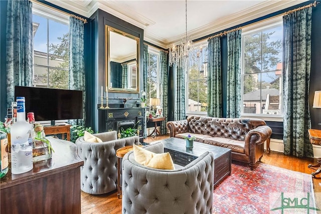 interior space with ornamental molding, wood-type flooring, a healthy amount of sunlight, and an inviting chandelier