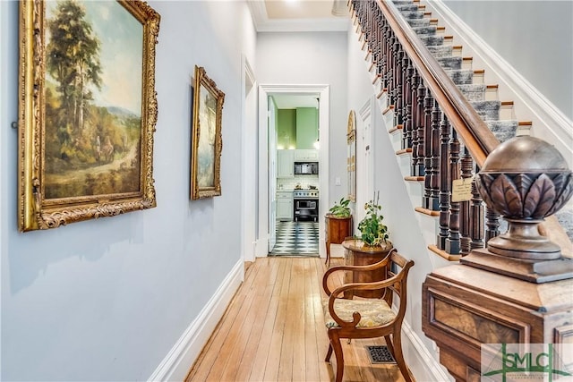 corridor with hardwood / wood-style flooring and crown molding