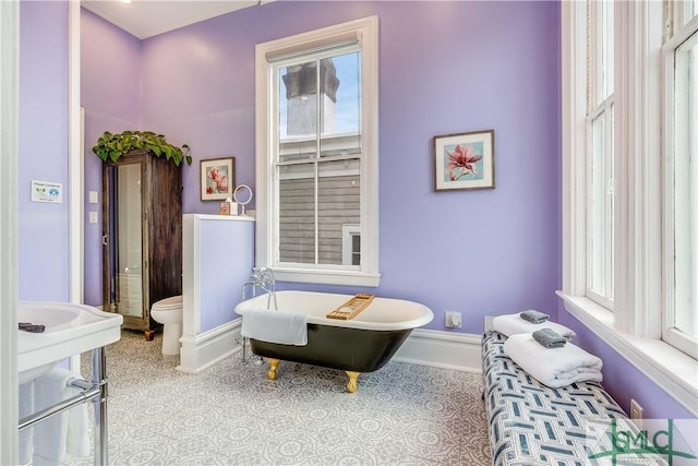 bathroom featuring a tub to relax in and toilet