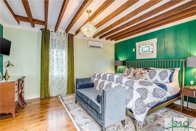 bedroom featuring a chandelier, beam ceiling, light hardwood / wood-style flooring, and a wall mounted AC