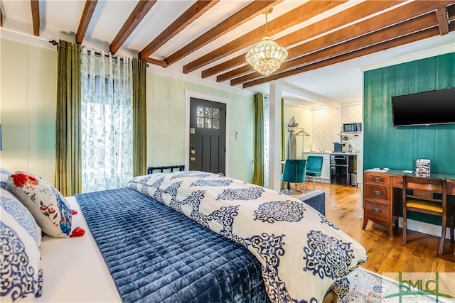 bedroom with beamed ceiling, wood-type flooring, and an inviting chandelier