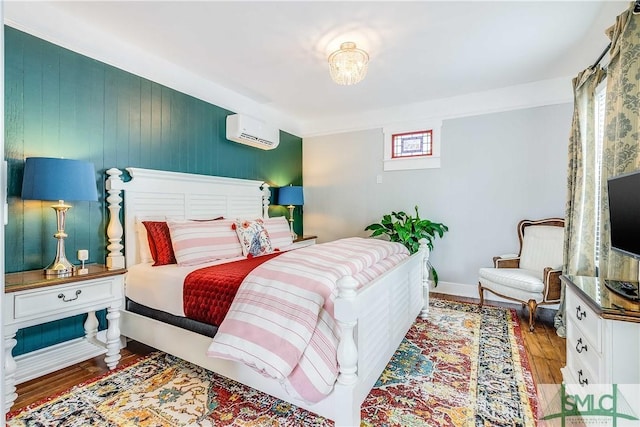 bedroom featuring wood-type flooring and a wall mounted AC