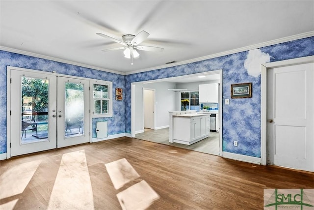 interior space featuring ceiling fan, ornamental molding, light hardwood / wood-style flooring, and french doors