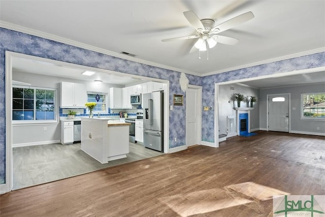 kitchen featuring white cabinetry, hardwood / wood-style floors, a center island, and stainless steel appliances