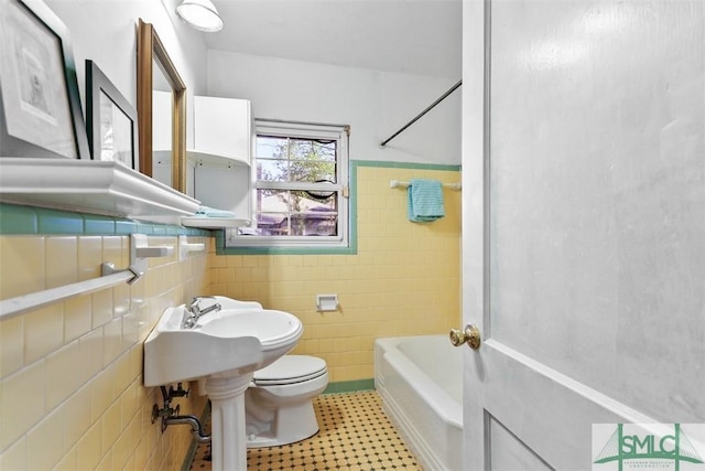 full bathroom with shower / tub combination, sink, tile walls, and toilet