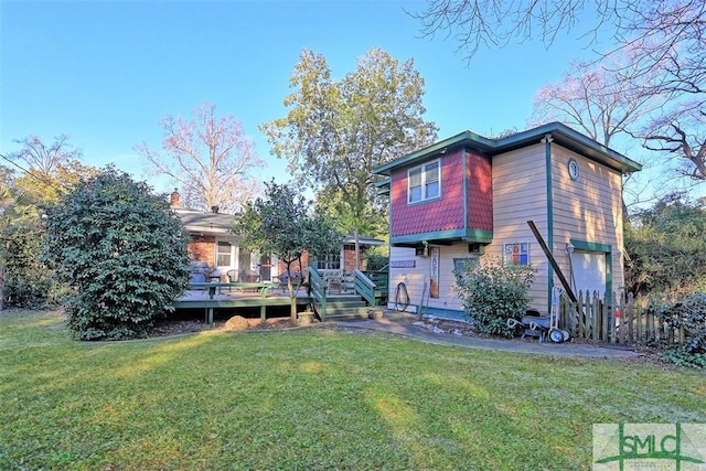 back of house with a garage, a deck, and a lawn