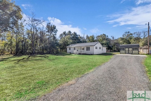 view of front of house with a front lawn and a storage shed