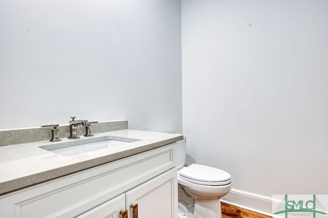 bathroom featuring hardwood / wood-style floors, vanity, and toilet