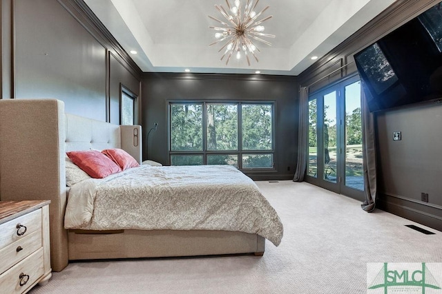 bedroom featuring a notable chandelier, light carpet, access to outside, and a tray ceiling