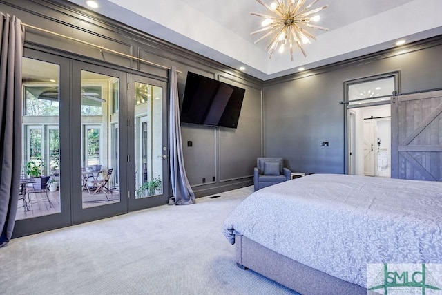 carpeted bedroom with access to outside, french doors, ceiling fan with notable chandelier, a barn door, and ornamental molding