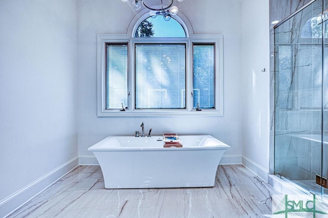 bathroom with shower with separate bathtub and a notable chandelier