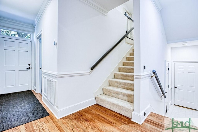 foyer entrance with wood-type flooring and ornamental molding