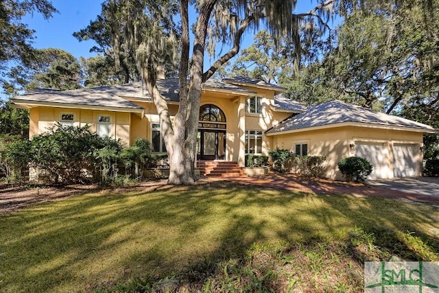 view of front of home with a front yard and a garage