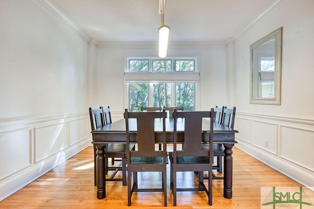 dining room featuring light hardwood / wood-style flooring and ornamental molding