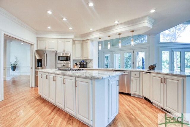 kitchen featuring kitchen peninsula, pendant lighting, white cabinets, and stainless steel appliances