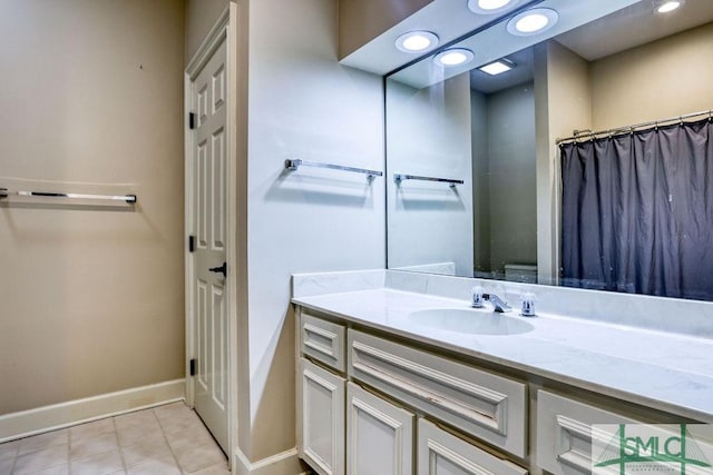 bathroom with a shower with curtain, vanity, and tile patterned floors