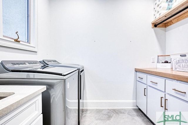 laundry room featuring washer and clothes dryer and cabinets