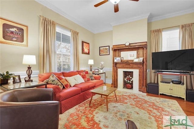 living room with ceiling fan, wood-type flooring, and ornamental molding