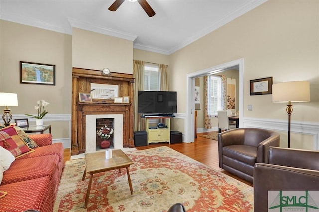 living room featuring ceiling fan, light hardwood / wood-style floors, and ornamental molding