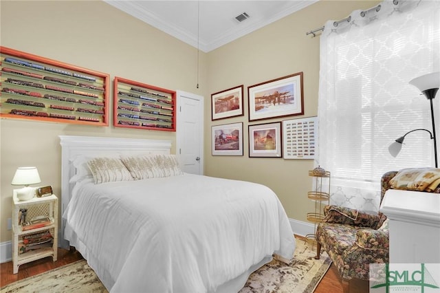 bedroom with crown molding and hardwood / wood-style floors