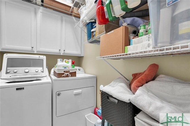 clothes washing area featuring washing machine and clothes dryer and cabinets