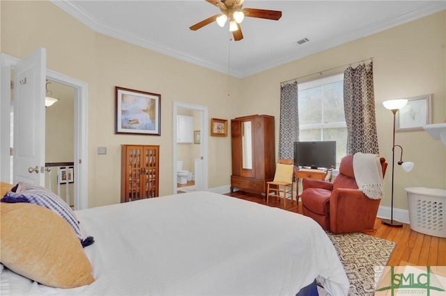 bedroom featuring light hardwood / wood-style flooring, ensuite bath, ceiling fan, and ornamental molding