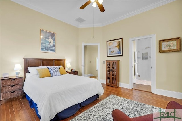 bedroom featuring ensuite bathroom, ceiling fan, wood-type flooring, and crown molding