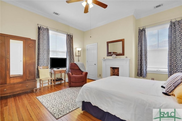 bedroom with ceiling fan, crown molding, and wood-type flooring