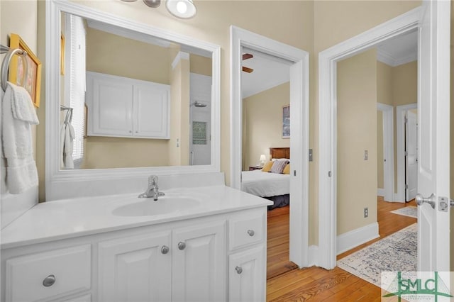 bathroom with vanity, wood-type flooring, and ornamental molding