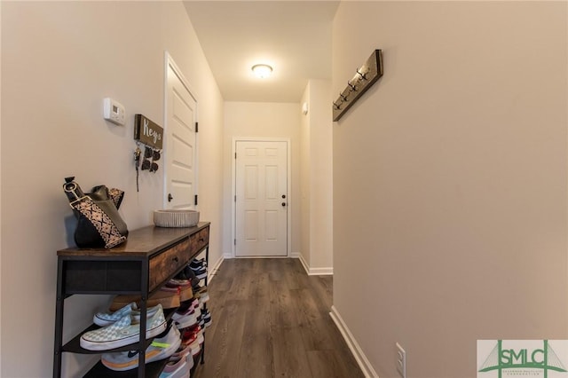 doorway to outside with dark wood-type flooring and baseboards