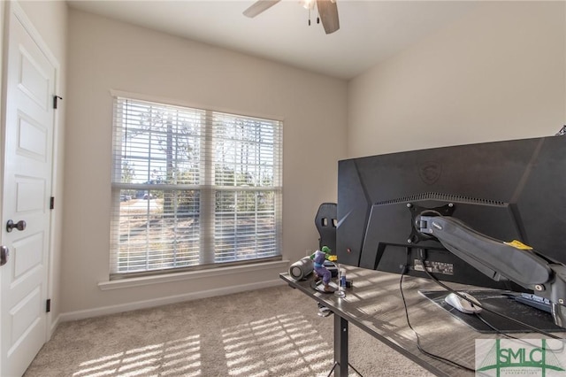 carpeted office with baseboards and a ceiling fan