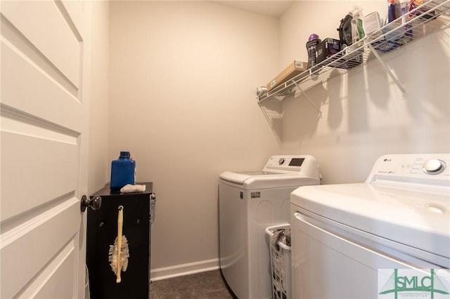 laundry area with laundry area, baseboards, and washer and clothes dryer