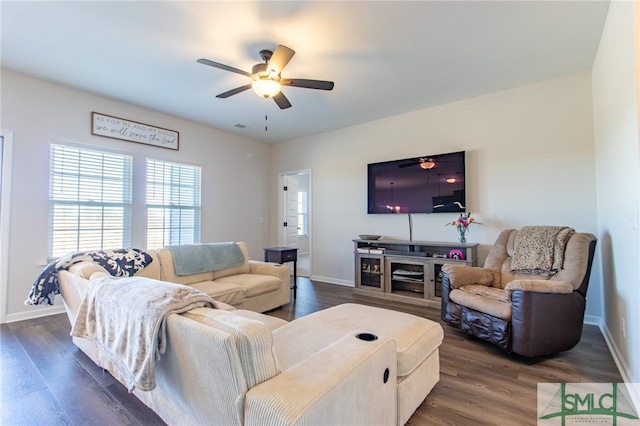 living area featuring dark wood-style floors, a ceiling fan, and baseboards