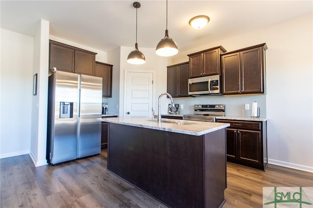 kitchen featuring a sink, dark brown cabinets, appliances with stainless steel finishes, dark wood-style floors, and tasteful backsplash