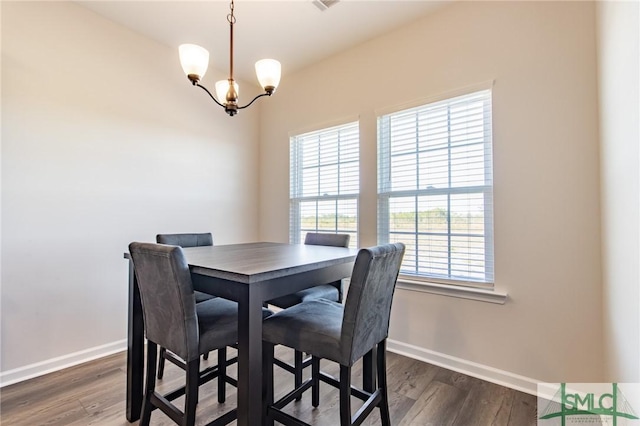 dining room featuring an inviting chandelier, baseboards, and dark wood finished floors