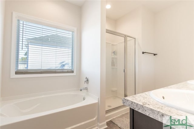 bathroom with a garden tub, a shower stall, and vanity