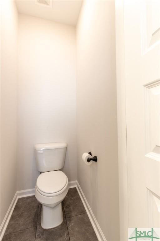 bathroom with baseboards, visible vents, toilet, and tile patterned floors