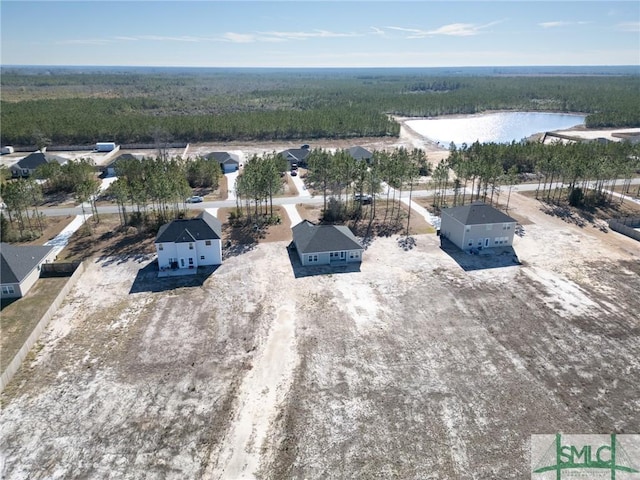 drone / aerial view featuring a water view and a wooded view