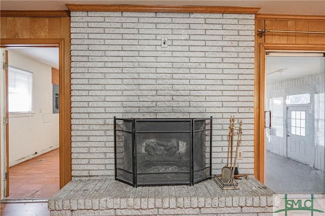 room details with hardwood / wood-style floors, a brick fireplace, and wooden walls