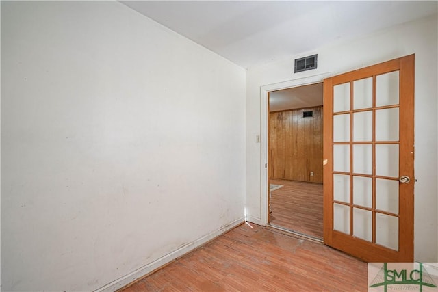 empty room with french doors and light hardwood / wood-style floors